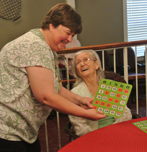 caregiver checking elderly woman's bingo card