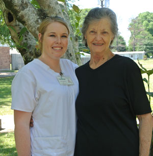 caregiver and elderly woman posing for the camera